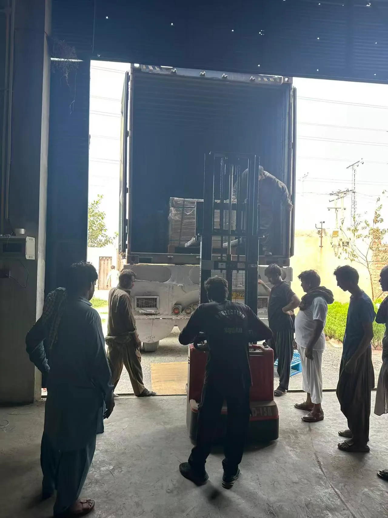 Business photo supplied by HENGLORY: workers using a forklift to handle cargo at a container